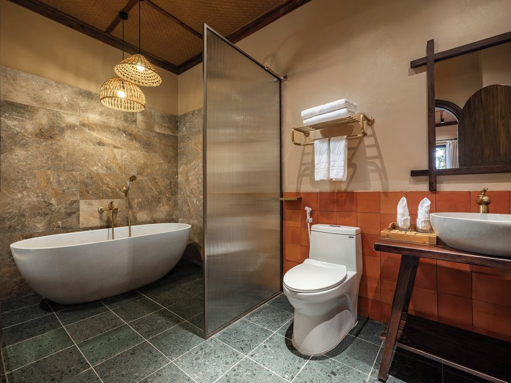 A bathroom with a freestanding bathtub, a shower enclosure, a toilet, and a vanity with a sink.