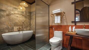 A bathroom with a freestanding bathtub, a shower enclosure, a toilet, and a vanity with a sink.