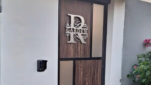 Une entrée moderne, ornée d’une grande enseigne décorative sur laquelle on peut lire « GARDEN R ».