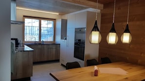 Ett modernt kök med träskåp, en stor köksö och hängande lampor.