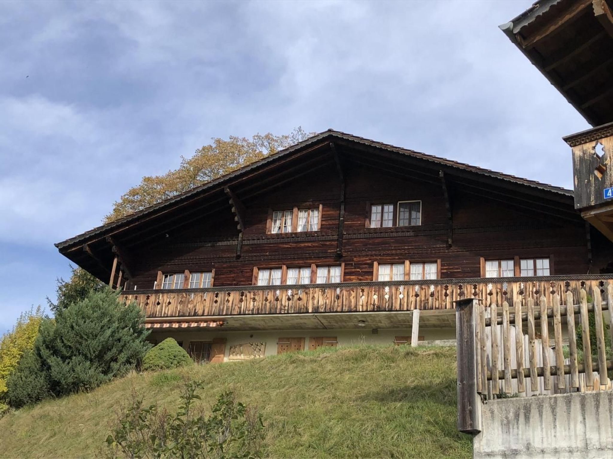 Tipico chalet in legno con balcone, situato su un pendio.