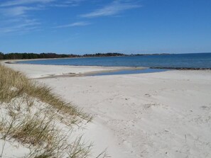 A beach with white sand and sparse grass. - Niedliches Schwedenhaus. by Interhome (Mönsterås)
