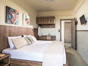 A modern bedroom with a large bed, wooden headboard, and two paintings on the wall. - Modernes Studio für 3 Personen, Pool- und Gartenblick by Interhome (Gerakini)
