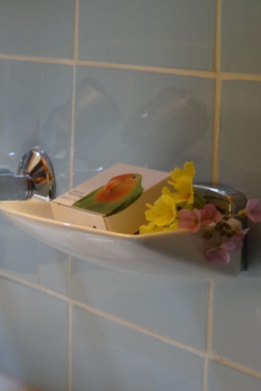 A bathroom with a white sink, a mirror, and a tiled wall.