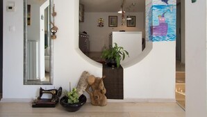 A hallway with a mirror, a wooden sculpture, and a potted plant. - Wohnung in Rijeka mit Terrasse und Grill by Interhome (Rijeka)