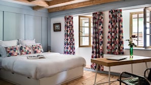 A bedroom with a bed, a desk, and a chair. There are curtains on the windows, and a picture frame on the wall. - Chateau Duplex Ferme by Interhome (Marnand)