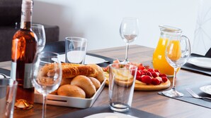 Ein Frühstückstisch mit Brot, Gebäck, Obst und Getränken.