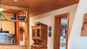 A cozy interior with wooden floors, a dining area with wooden furniture, a kitchen with wooden cabinets, and a fireplace. - Rottal 4 Bett Wohnung by Interhome (Lauterbrunnen)