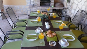 Een ontbijttafel gedekt met groene tafelmatten, borden en bestek.