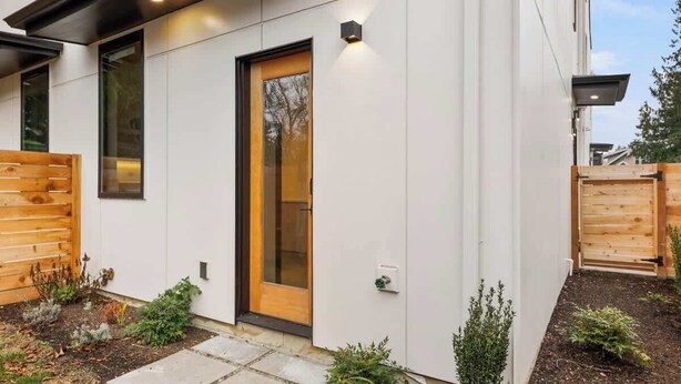 A modern house with a wooden door, a small garden, and a white exterior wall. - Modern Seattle Stay • Rooftop Views & Ensuite BRs (Seattle)