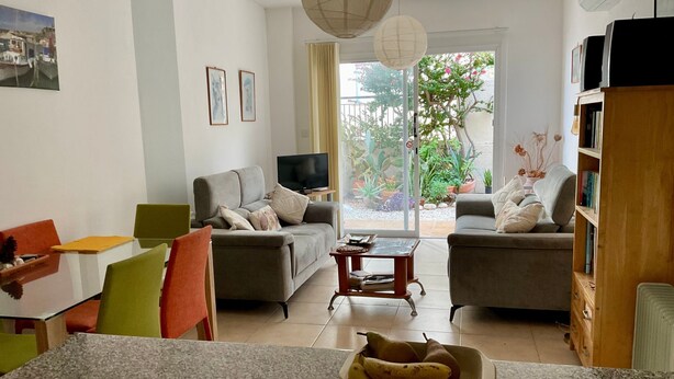 A modern living room with a sofa, chairs, a TV, and a dining area with a table and chairs. - MYHIDEAWAY APARTMENT mit kostenlosem WiFi by Interhome (Peyia)