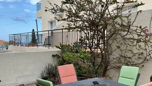 An outdoor seating area with a table and chairs, surrounded by plants and a building. - MYHIDEAWAY APARTMENT mit kostenlosem WiFi by Interhome (Peyia)