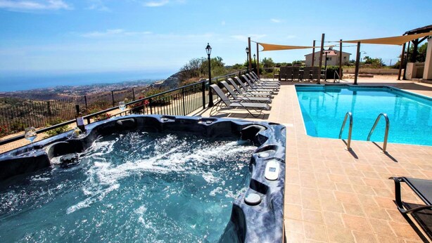 A hot tub with a view of the ocean, a swimming pool, and lounge chairs. - Villa mit Blick auf die Berge und Whirlpool by Interhome (Kathikas Village)