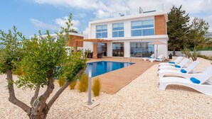 A modern two-story house with a swimming pool, outdoor seating, and a view of the sea. - Coral Elite Residence mit Pool und Whirlpool by Interhome (Peyia)