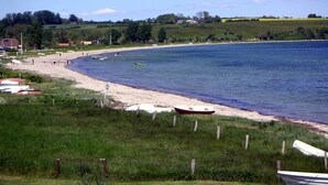 Une plage côtière avec des bateaux et un rivage sablonneux.