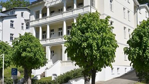 Un edificio blanco con un balcón y un cartel que dice "Villa Celina".