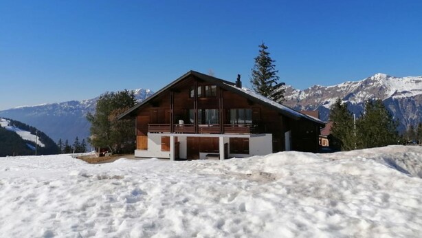 A wooden cabin with a balcony, surrounded by snow and mountains. - Hüttbödeli by Interhome (Brienz)