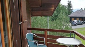 A covered outdoor area with two blue chairs and a small white table. - Hüttbödeli by Interhome (Brienz)