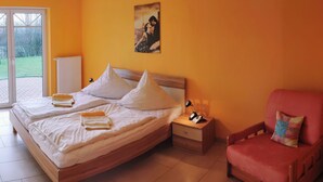 Un dormitorio con cama, mesita de noche, silla y un cuadro en la pared.