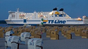 Een veerboot met het TT-Line logo, afgemeerd in een haven met rijen postvakken voorzien van nummers.