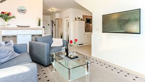 Ein modernes Wohnzimmer mit einer Couch, einem Couchtisch und einer Küche im Hintergrund.