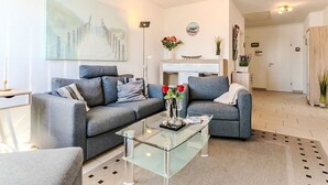 Ein modernes Wohnzimmer mit einer Couch, einem Couchtisch und Kunstwerken.