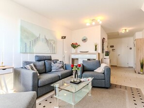 Een moderne woonkamer met een bank, salontafel en kunstwerk.