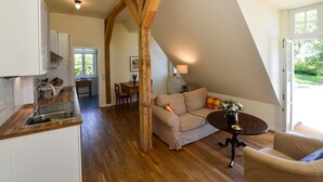 A spacious loft with a kitchen, dining area, and seating area. - Wohnung im zweiten Obergeschoss des Gutshauses by Interhome (Gingst)