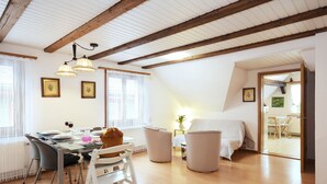 Une pièce spacieuse comprenant un coin repas, un lit et un escalier menant à un niveau supérieur.