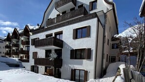Un hotel de varios pisos con balcones y un paisaje nevado.