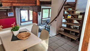 Un comedor con una mesa, sillas, una cesta y una planta en maceta.