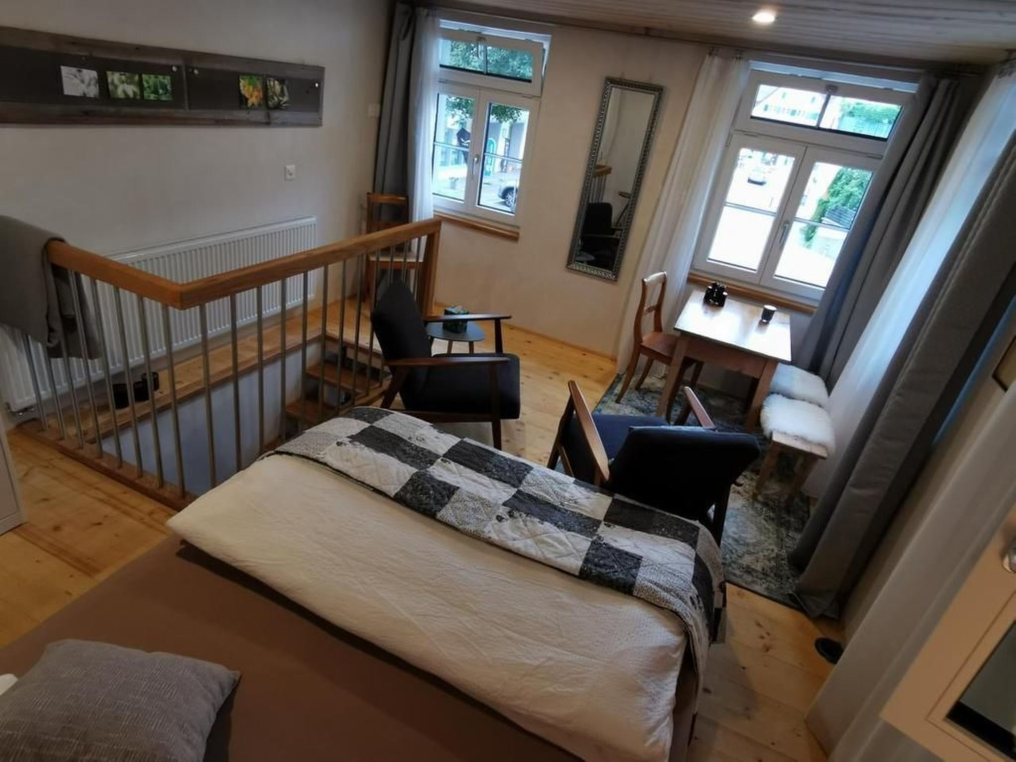 A bedroom with a bed, a chair, a desk, and a window.