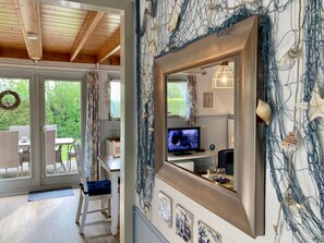 A room with a large mirror, a television, and a view of the outdoors. - 181 Urlaubsruhe by Interhome (Anjum)