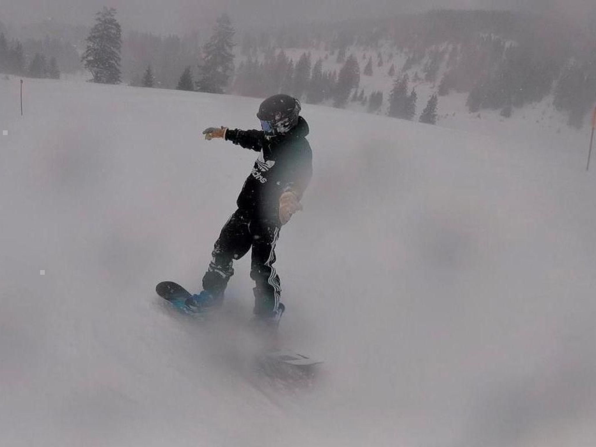A snowboarder in motion on a snowy slope.