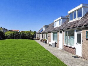 A row of houses with a well-maintained lawn and a paved walkway. - Sommerhaus "De Zeester" by Interhome (Egmond aan Zee)