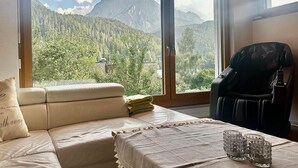 A room with a bed, a massage chair, and a table with glasses. - Chasa Stefania by Interhome (Scuol)