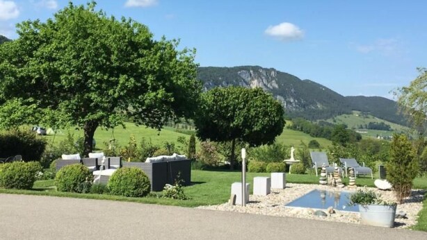 Ein Campingplatz mit Zelten, einem Schwimmbad und einem Berg im Hintergrund.