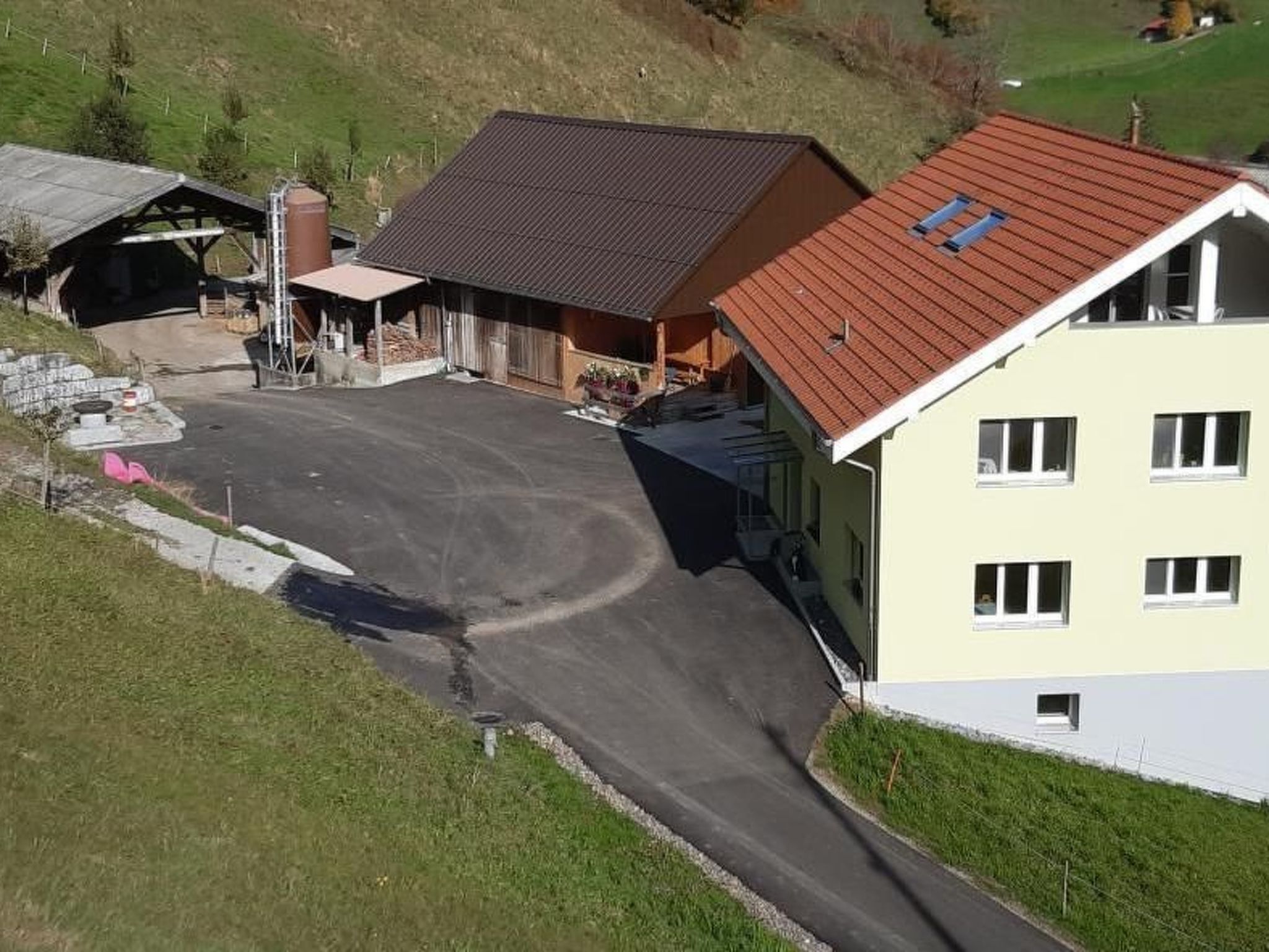 Un quartier résidentiel avec une maison dotée d’un toit en pente, d’un garage et d’une allée.