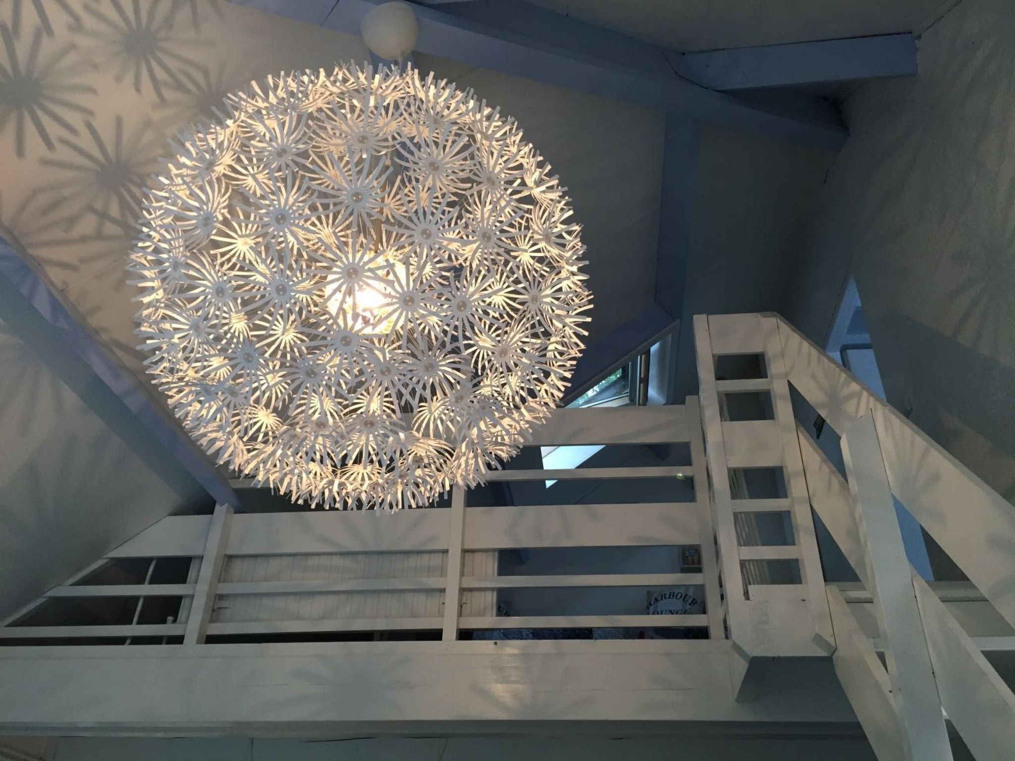 Een modern interieur met een opvallende, sferische lamp en een trap.