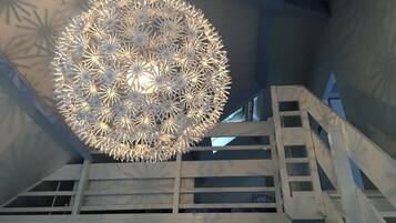 Een modern interieur met een opvallende, sferische lamp en een trap.