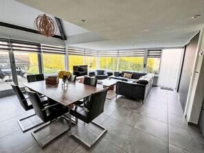 Un espace repas moderne avec une grande table, des chaises et un canapé.