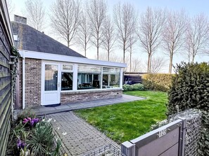 A modern house with a brick exterior, large windows, and a well-maintained lawn. - Vacation home  by Interhome (Stavenisse)