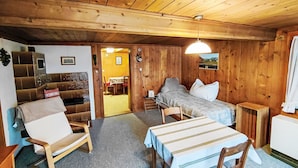 Een houten interieur met een bed, een bank, een tafel en een stoel.