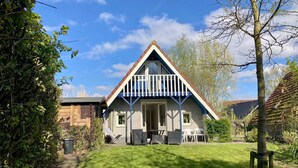 A two-story house with a sloped roof, a balcony, and a front porch. - 162 Grachthaus by Interhome (Anjum)