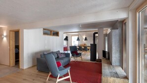 A modern living room with a grey sofa, red rug, and wooden flooring. - Bellezza - Bio Bergün by Interhome (Bergün)