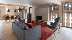 A modern living room with a grey sofa, red rug, and a TV on a wooden stand. - Bellezza - Bio Bergün by Interhome (Bergün)