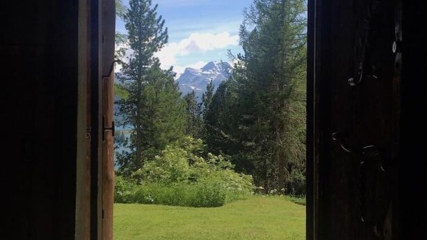 A doorway leading to a view of a mountainous landscape with trees and a clear sky. - Chesa Bindschedler by Interhome (St. Moritz)