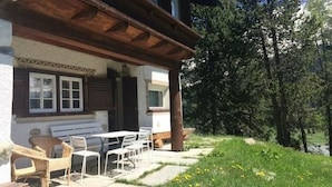 A chalet with a wooden balcony, outdoor seating, and a view of a forested area. - Chesa Bindschedler by Interhome (St. Moritz)