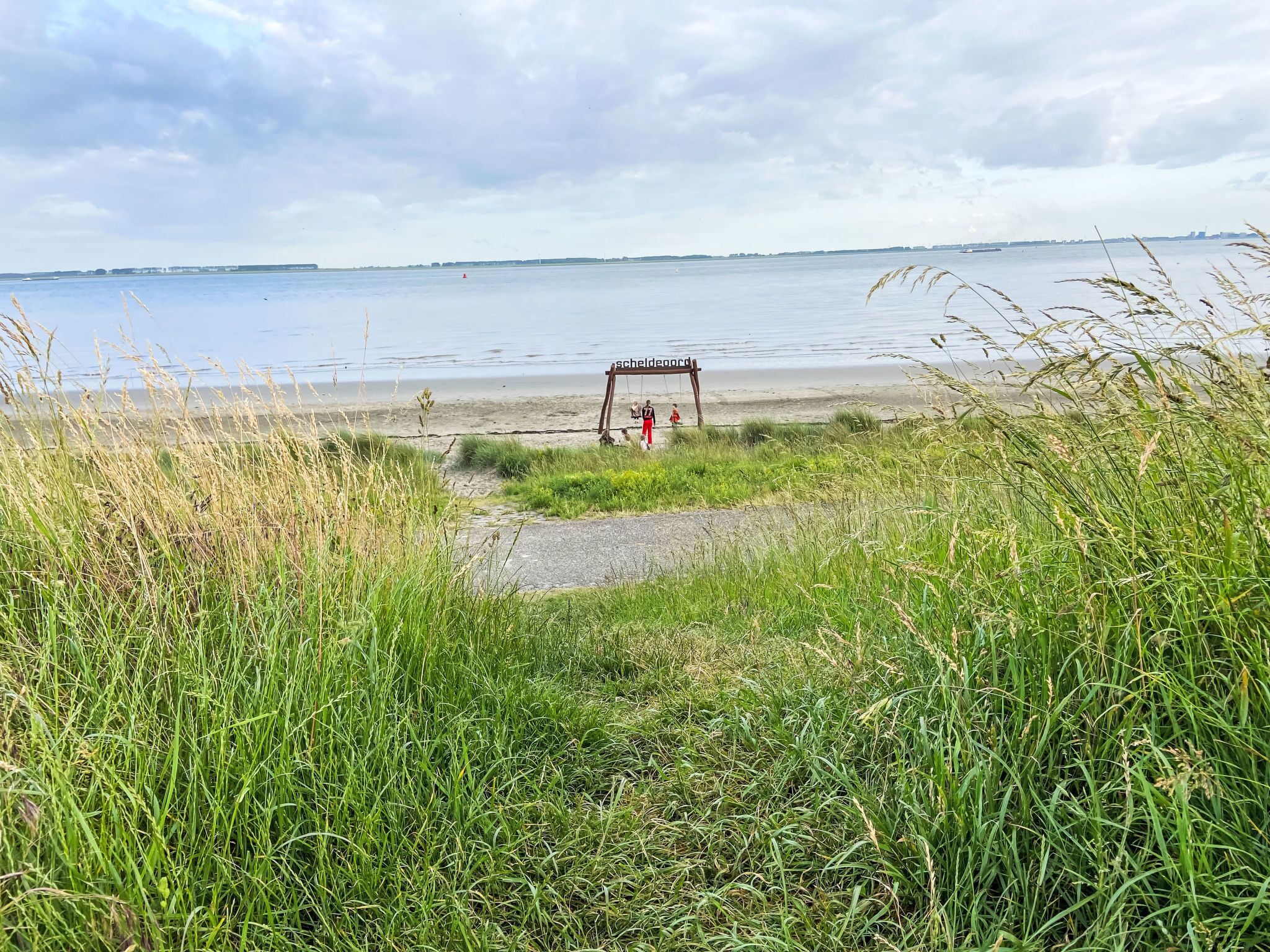 Une plage avec une balançoire et un panneau indiquant « Schildeborg ».