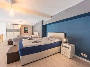 Un dormitorio moderno con una cama grande, mesitas de noche y un armario.